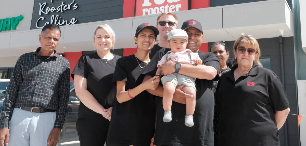 Franchisees Priya and Hiren Patel (centre, with baby Kian) with Mum (second from right) and Dad (far left), and business consultants Kerry Yaghoubpour, Trent Walton and Janette Nagy outside the new Red Rooster in West Bathurst. Picture by James Arrow.