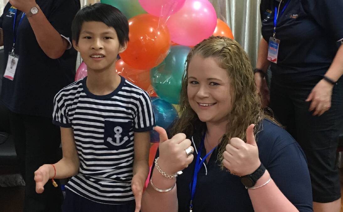 HELPING HAND: Orange's Emma Carrall with one of the children at the Suzhou Wujiang Social Welfare Institute where TAFE Western students volunteered during a recent rip to China. Photo: CONTRIBUTED
