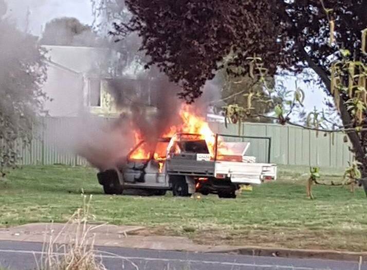 CRIMINAL ACT: The Mazda ute is seen burning after it was set alight on grassland next to Lone Pine Avenue on Sunday morning. Photo: FACEBOOK