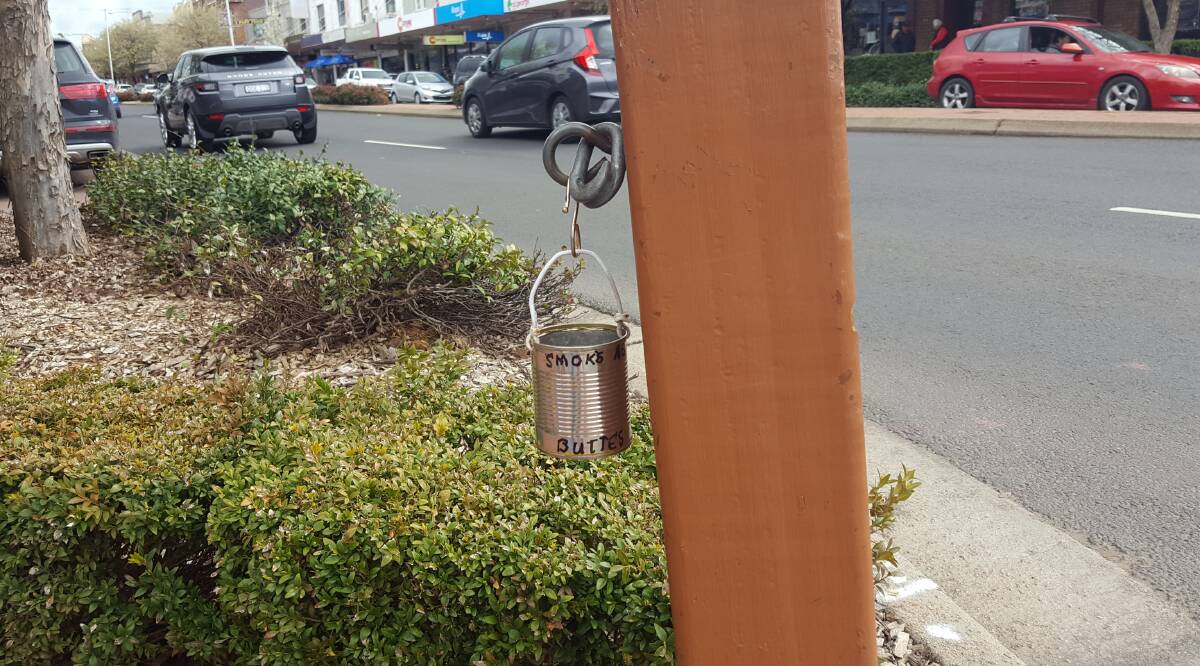 BUTTING IN: The home-made cigarette butt bin hanging off a post.