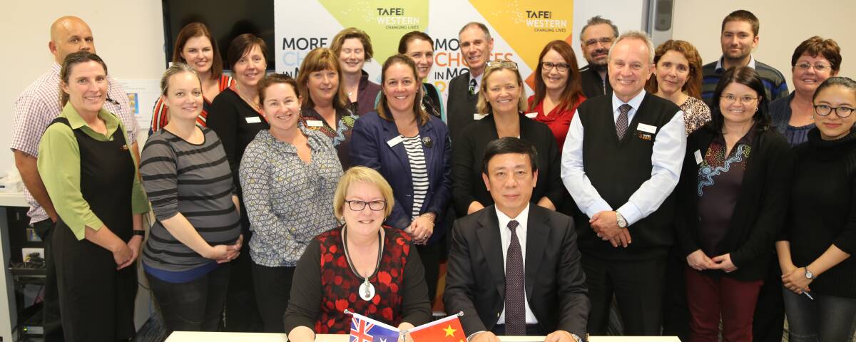 SIGNING ON: TAFE Western Institute Director Kate Baxter and Shanghai AXGZ Chairman Lawrence Feng sign the agreement surrounded by TAFE Western staff.