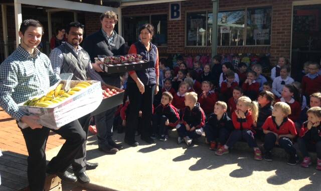 LET'S DIG IN: Woolworths manager Matthew Radburn brought a huge supply of fruit and vegetables for Orange Chrtistian School students to try. Photo: CONTRIBUTED
