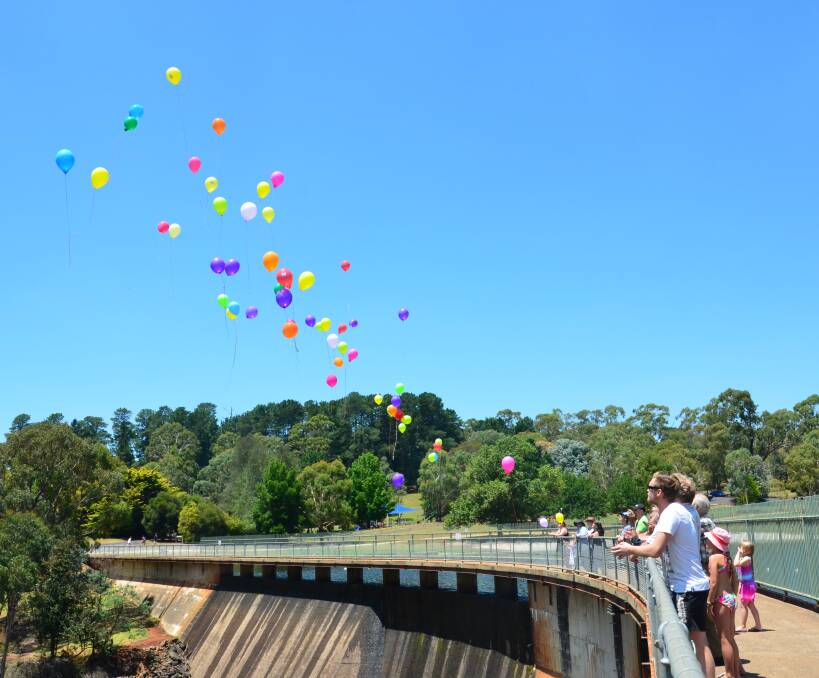 TOUCHING TRIBUTES: Balloons with messages for those lost to depression and other mental health issues are released into the air at Lake Canobolas on Saturday. Photo: DECLAN RURENGA 0121drskynotes13