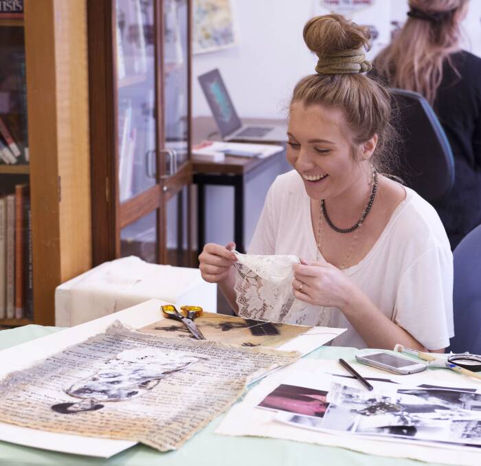 HARD AT WORK: TAFE visual arts student Delaynie Jones busy preparing her works for the 'Splash' exhibition. Photo: CONTRIBUTED