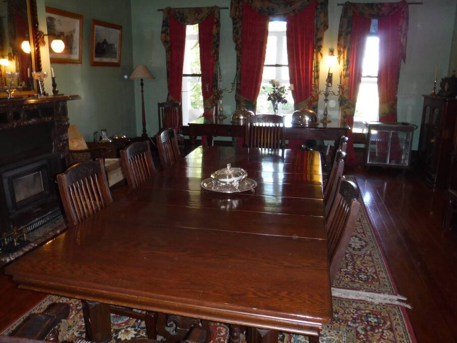 FOR SALE: A large oak extension dining table with turned wooden legs on ceramic castors.