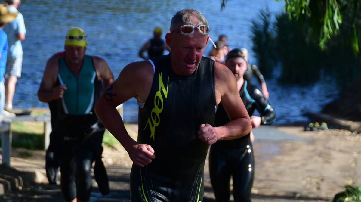 FEELING IT: Orange's Phil Tudor attempts to power his way up out of the water after completing his swim along the Macquarie River. Photo: PAIGE WILLIAMS