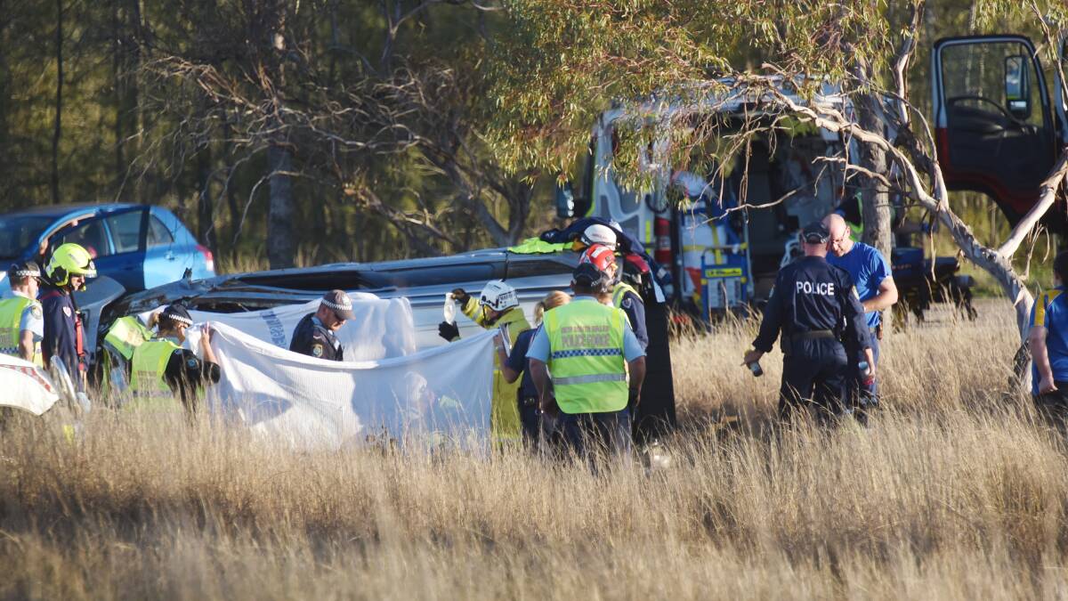 Charges laid: Emergency services work to free the trapped occupants at the scene of the July 19 crash. Photo: Geoff O'Neill 