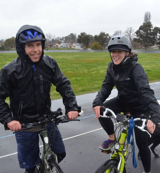 BRAVING THE RAIN: Jim and Alicia Gowing rode their bikes at Orange Velodrome despite Bike Fest's postponement. Photo: DANIELLE CETINSKI 0918dcvelodrome1