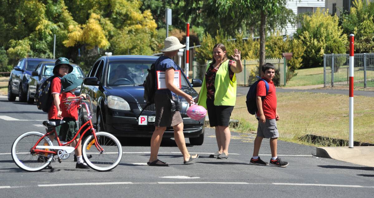 FILLING IN: Teacher Rachel Livingstone directs traffic outside Glenroi Heights Public School as the school lacks a trained crossing supervisor. Photo: JUDE KEOGH 