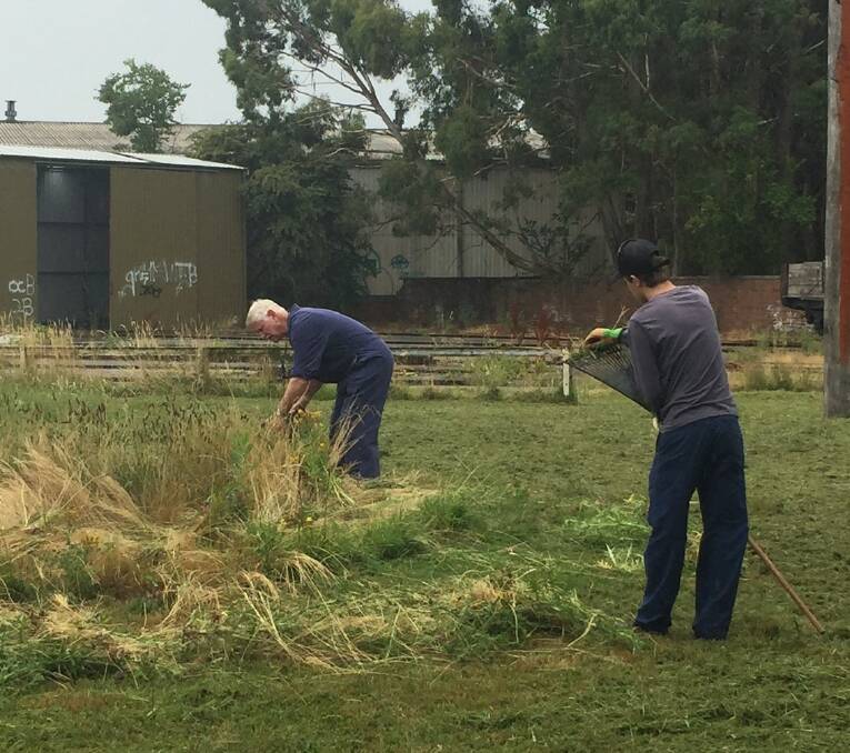 CLEANING UP: Volunteers Dennis Turner and Mat Elsmore clear weeds at the East Fork site where the trains will be based.