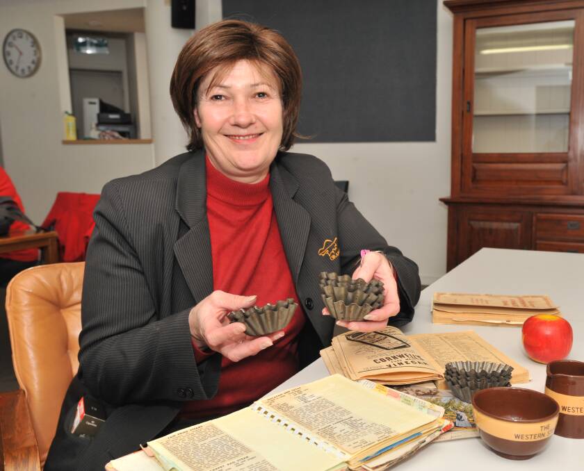 TREASURES: Orange Regional Museum manager Alison Russell holds little tart tins made by her grandfather 70 years ago. Photo: JUDE KEOGH 0613jkmuseum3