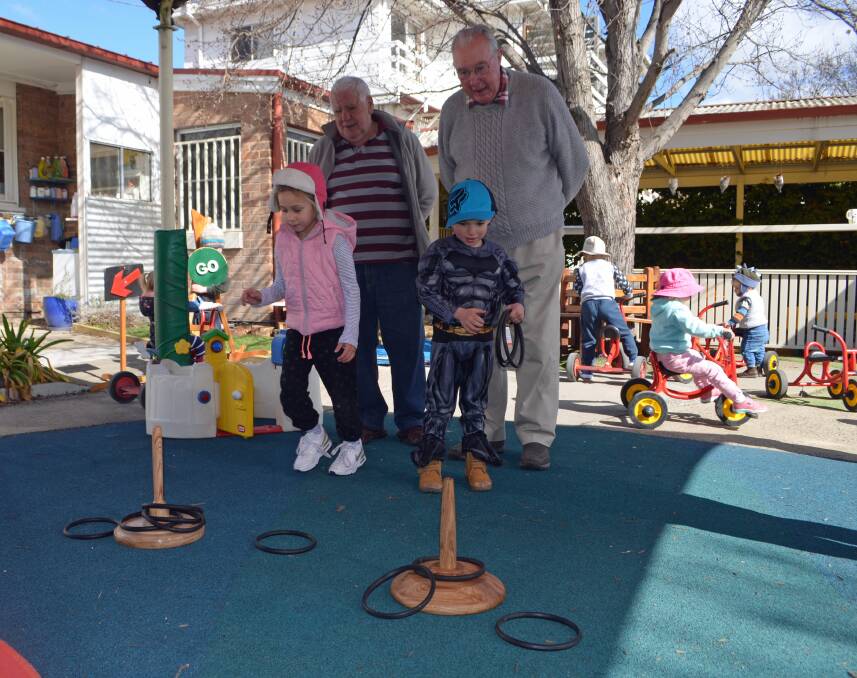 CHILD'S PLAY: Brian McEvoy and Brian Collins watch Harriett and Morne play with the new quoits set in the Orange City Council's Occasional Care playground. Photo: Supplied