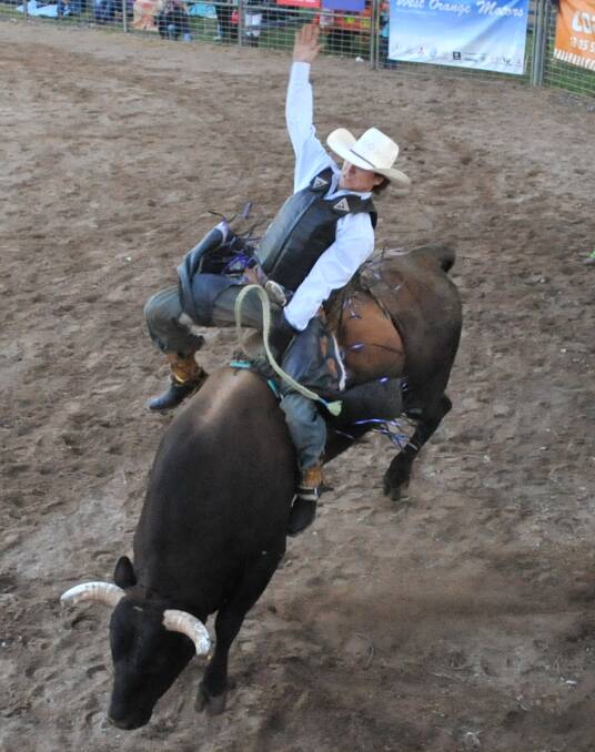 HOLDING ON: Troy Burtenshaw clings to the back of a bucking bull.