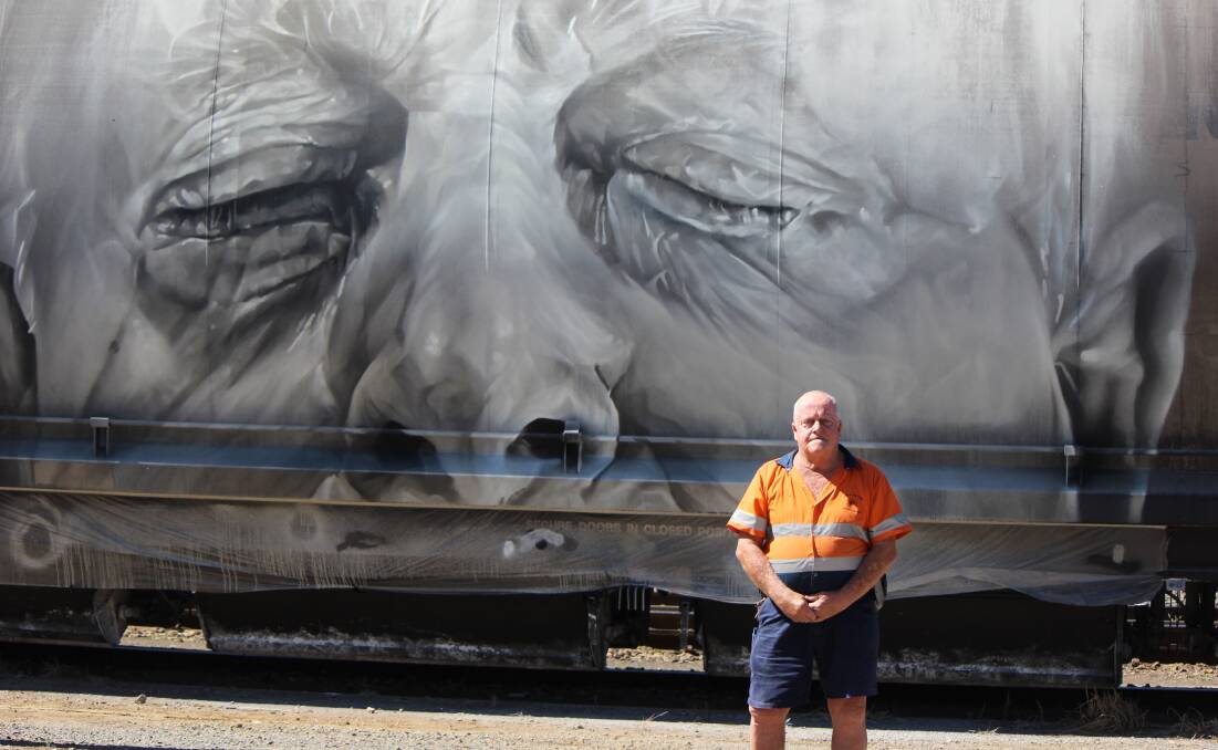 CLOSE UP: Mill worker Ron "Fox" Bennett with artist Guido Van Helten's portrait of his face on the side of a railway wagon for a new TV show. Photo: GENYA MILLER