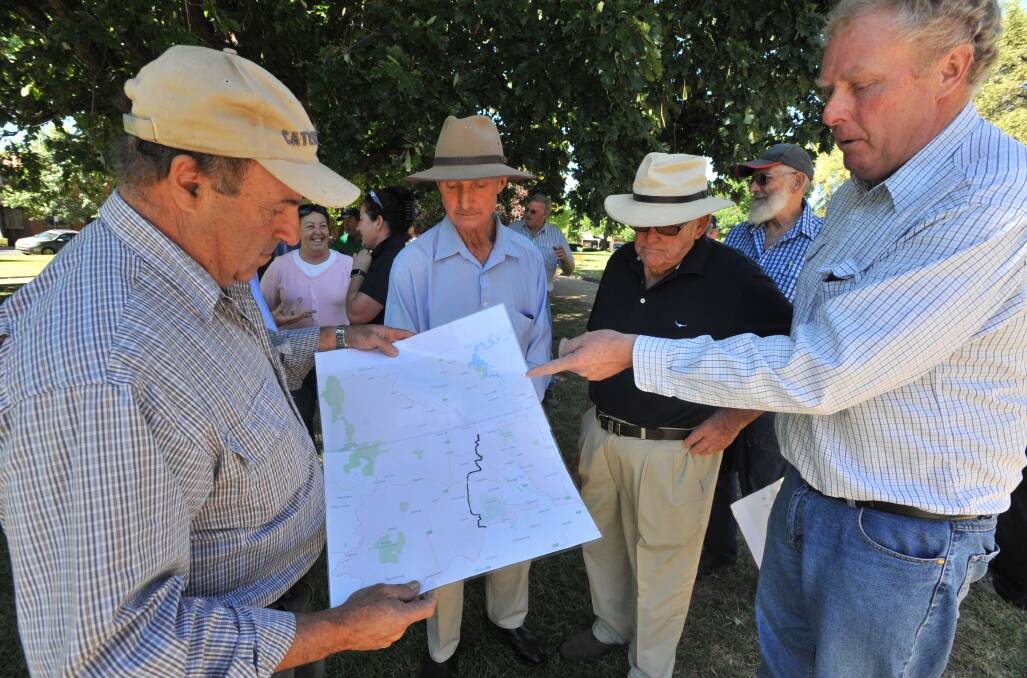 BATTLE LINE: Eastern Cabonne residents Joe Caltabiano, Allen Hawke and Ian McIvor examine a proposed border change map with NSW Farmers' Bruce Reynolds in Robertson Park on Tuesday. Photo: JUDE KEOGH