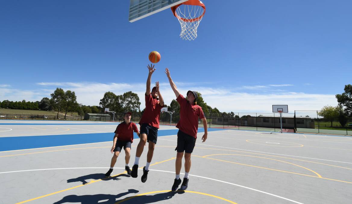 NEW FEEL: Students Charlie Kemp, Kaden Williams and Charlie Kilby try out the new courts at James Sheahan school. Photo: JUDE KEOGH 0308jkshs1