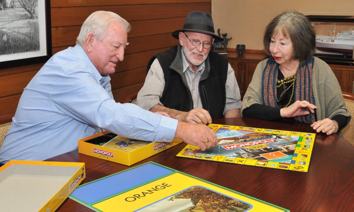 GAME ON: Mayor Cr John Davis plays the game with Borrodell's Borry Gartrell and Gaye Stuart-Nairn. Photo: JUDE KEOGH 0615jkmonopoly1