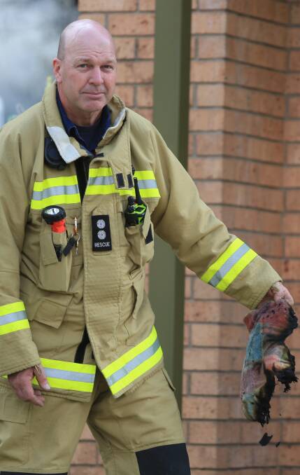 BURNT: Station officer Tom Fenlon holds the remains of the electric blanket which sparked a unit fire in McLachlan Street. Photo: PHIL BLATCH