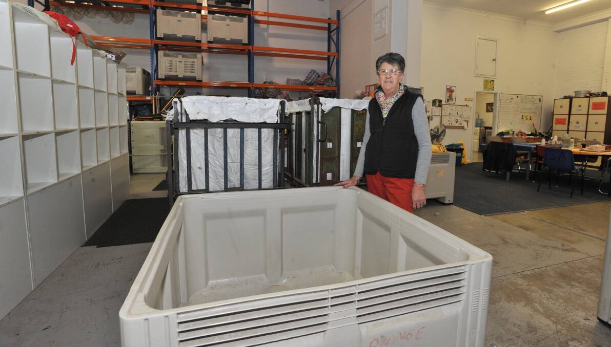 EMPTY: Salvation Army Family Store volunteer Jenny Agland surrounded by empty bins and shelves after winter clothing donations dried up. Photo: JUDE KEOGH 0607jksalvos2