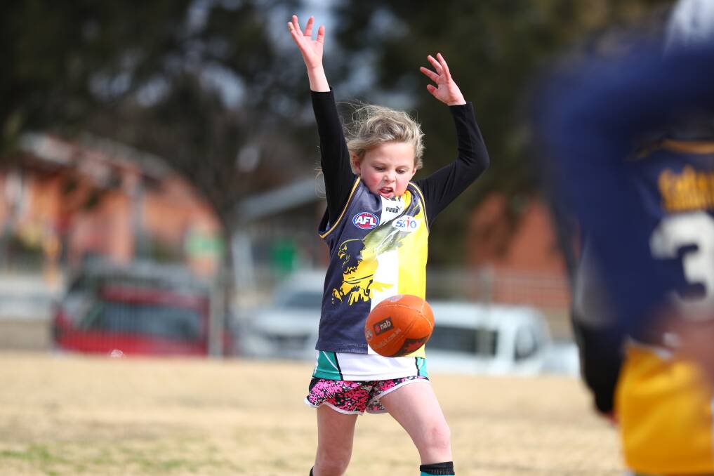 SINK THE BOOT IN: Jada Shackleton keeps her eye on the ball as she prepares to kick during the Auskick carnival at George Park. Photo: PHIL BLATCH