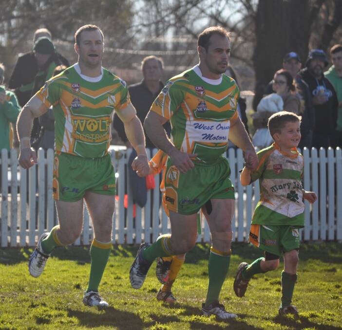 HAPPY CLUB: Orange CYMS' captain-coach Mick Sullivan and hooker James Wynne lead out a group of green and gold juniors at Wade Park - the seniors are the Group 10 club champions for 2016. Photo: NICK McGRATH