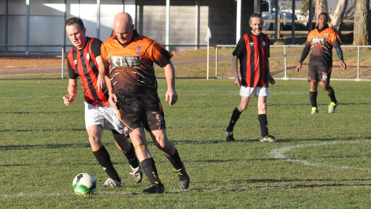 UNDER STRENGTH WINNERS : Millthorpe striker Roy Davis tries to get past Denley Moor defender Dave Gibson in Saturday’s match. Davis scored one goal and Tigers winger (at right) Stan Tulevu scored two in the 3-2 win.