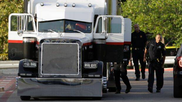 San Antonio police officers investigate the tractor-trailer where the gruesome discovery was made. Photo: ERIC GAY
