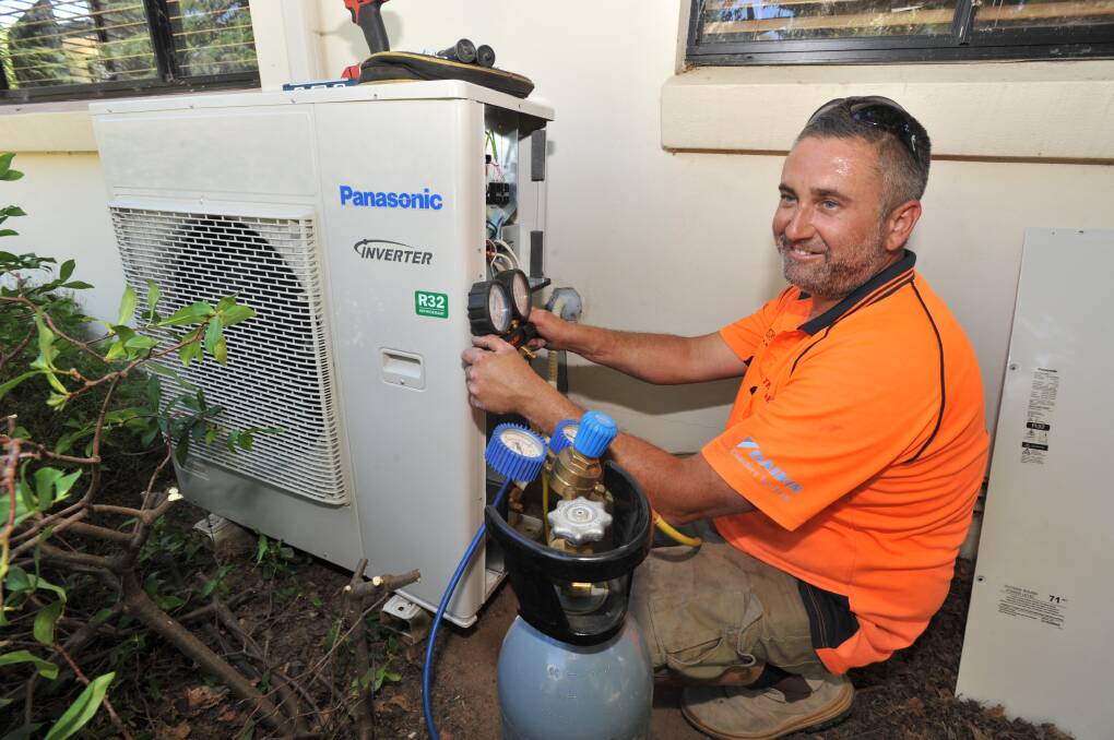 BEARING THE HEAT: ThermalAIR refrigeration mechanic Adam McDonald is among those working in hot conditions to keep people cool. Photo: JUDE KEOGH 0210jkaircon3 