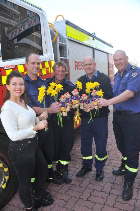 FIREFIGHTER THEME: Layla Carroll from the Cancer Council with Orange firefighters Dan Meacham, Andrew Townsend and lDave Beattie. Photo: JUDE KEOGH