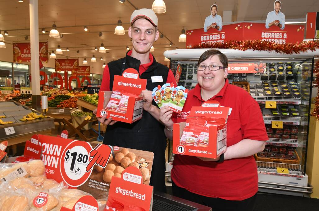 CHRISTMAS CHARITY: Coles staff members Tim Soares and Suzanne Hazell are hoping to raise money for Red Kite with the sale of gingerbread men. Photo: JUDE KEOGH