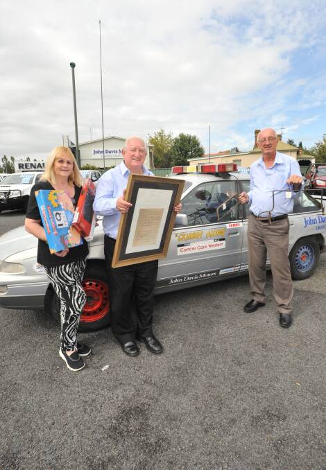 FUNDRAISING BID: Jan Savage from Cancer Care Western NSW with Cruisin-Along's John and Terry Davis who will host a fundraising auction on April 29. Photo: JUDE KEOGH