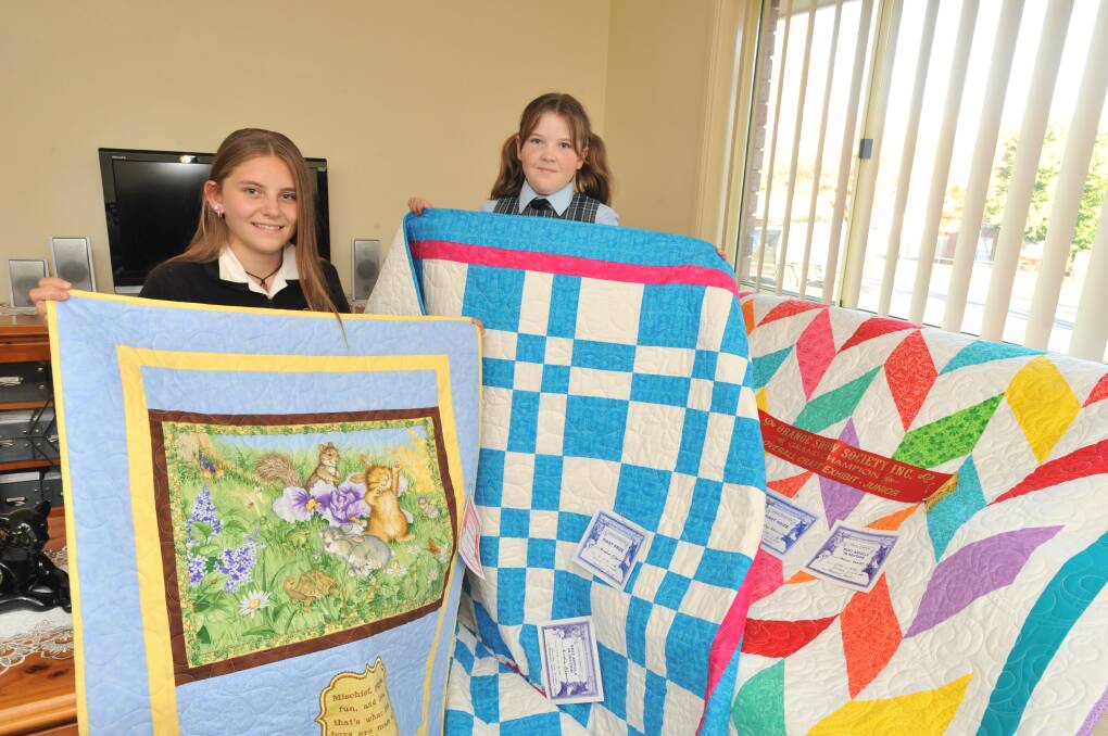 FAMILY SUCCESS: Jazlyn Blowes-Dean and Amelia Blowes with their award winning quilts including the grand champion quilt, right.