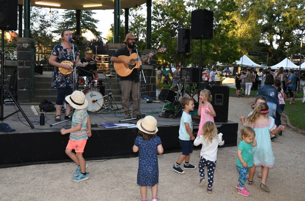 COUNTRY PARTY: Children dance along to Chloe and Jason Roweth at the night market in Robertson Park on Friday. Photo: JUDE KEOGH