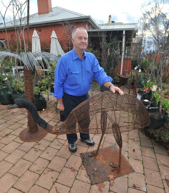 MISSING: Anything Grows owner Ken Kramer with an emu sculpture similar to one which was stolen this week. Photo: JUDE KEOGH 0825jkemu2