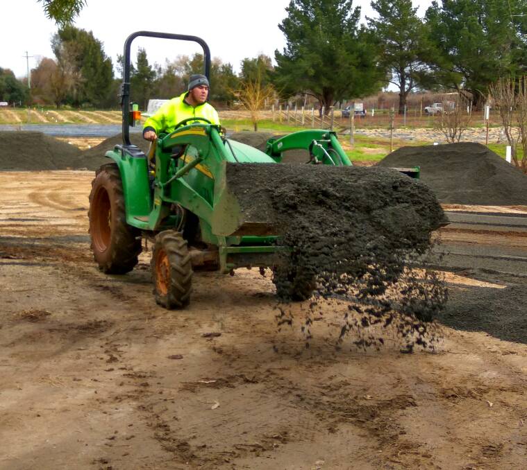 REPAIRS: Huntley Berry Farm employee Scott Nichols spreading donated gravel on Friday.