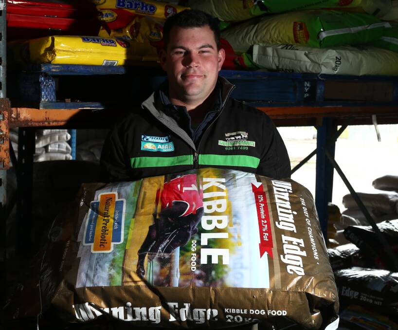 FOOD FOR THOUGHT: Mullion Produce, Pets & Saddlery employee Andrew Gallen with greyhound food the store currently sells to trainers and breeders in the region. Photo: PHIL BLATCH 0718pbdog4