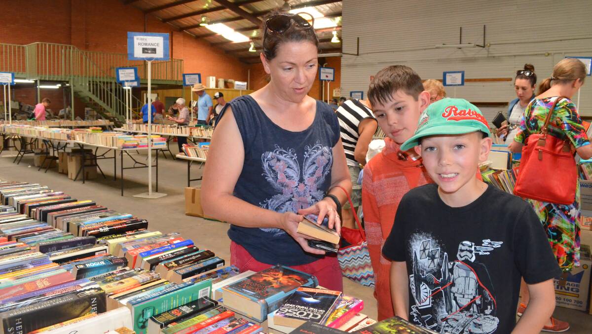 SPOILT FOR CHOICE: Jenelle Price, William Styles and Evan Price browsed through the books on offer at the Lifeline Book Fair in Orange last weekend. Photo: TANYA MARSCHKE 1119tmbook1