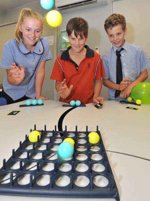 FUN AND GAMES: Lily Martin, Thomas and Andrew Bishenden enjoy some friendly rivalry. Photo: JUDE KEOGH 0314jkafter2