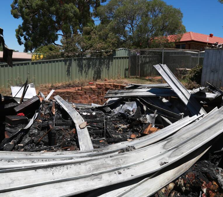COUNTING THE COST: Rubble in the family's backyard after the New Year's Day blaze which gutted their property.