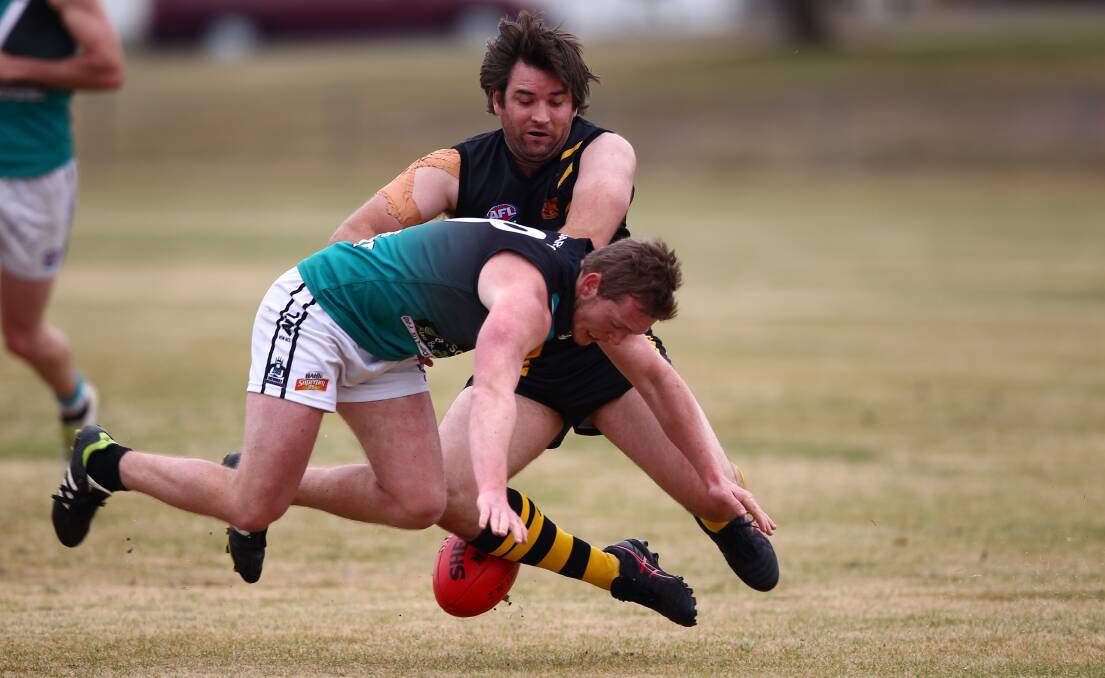 GOOD BATTLE: Outlaws' Grant Daley and his Orange Tigers rival attempt to win the lose ball in Saturday Central West AFL match at George Park. Photo: PHIL BLATCH