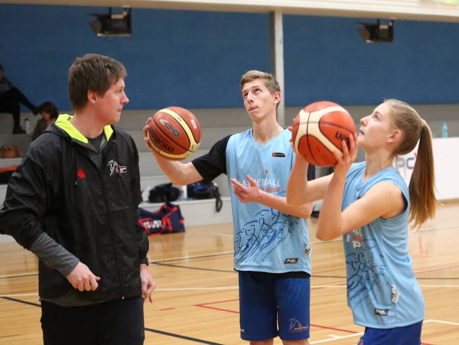 NOTHING BUT NET: Seebohm overlooks Kobe Mansell and Annie Miller's shooting technique. Photo: PHIL BLATCH 0720pbpcyc5