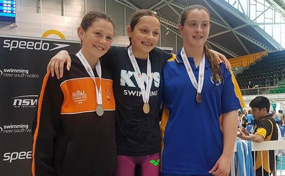 ALL SMILES: City of Orange's Breahna Burgess and Kinross' Collette Lyons share the 200m breastroke podium with Bomaderry's Shania Campbell-Cooper. Photo: TANYA CHAPMAN
