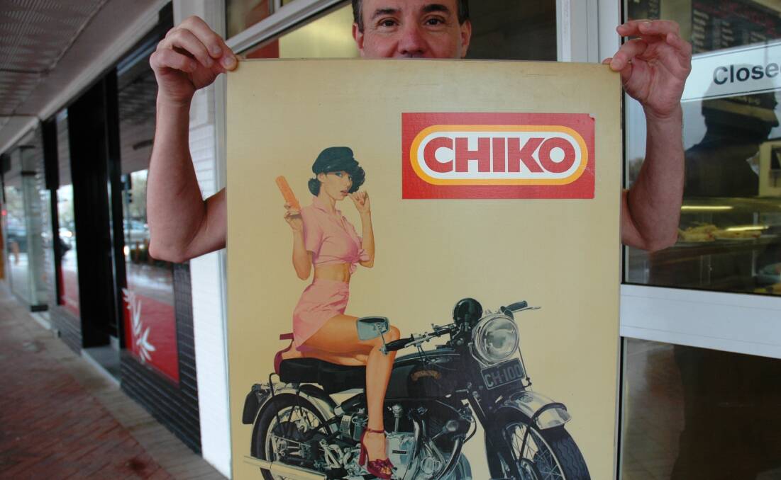 CHIKO ROLL: Jim Giameos of Stan’s Takeaway holds one of the Chiko motorcycle girl posters, now worth about $1,000 each.