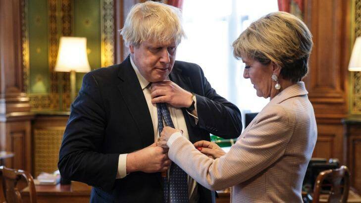 British Foreign Secretary Boris Johnson has his tie straightened by his Australian counterpart Foreign Minister Julie Bishop in his office at the Foreign and Commonwealth Office in London. Photo: Jack Taylor/Pool