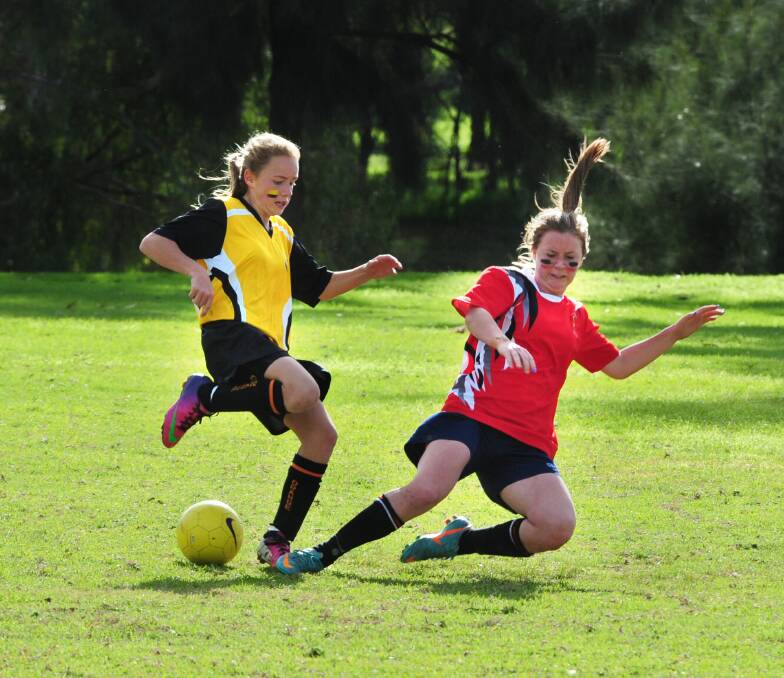 Emily McDonald from Orange and Jessica Fuller from Dubbo compete for the ball during last year's Astley Cup girls soccer match. Dubbo's 2015 cup campaign starts on Thursday.  
Photo: LOUISE DONGES