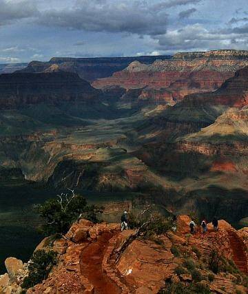 With the North Rim in the background, tourists hike along the South Rim of the Grand Canyon. 