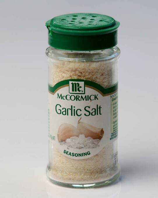 Rees seasons his pans with garlic salt. Photo: Wayne Taylor