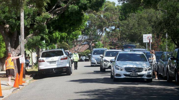 A car is told to move on after stopping in the middle of Kambala Road during after-school pick-up at Scots College on Friday. Photo: Fiona Morris