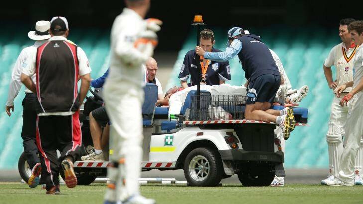 John Orchard, at the rear, works on Phillip Hughes at the SCG.  Photo: Mark Metcalfe/Getty Images