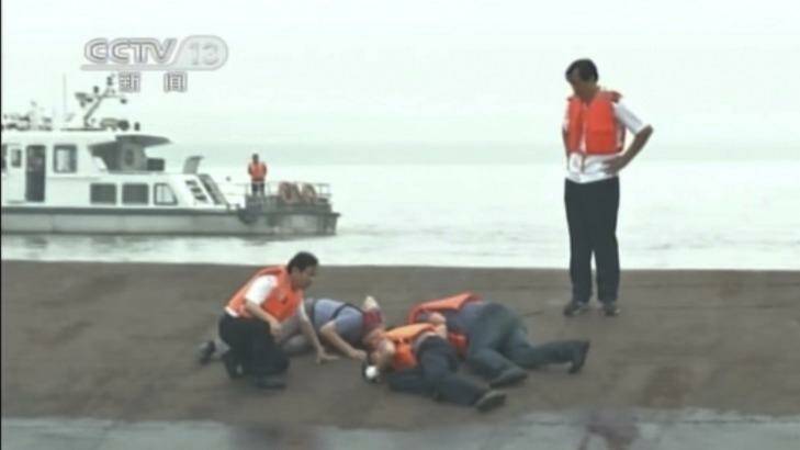 In this image taken from video released by China's CCTV, rescue workers listen for a response to their tapping on the hull of a capsized ship on the Yangtze River.